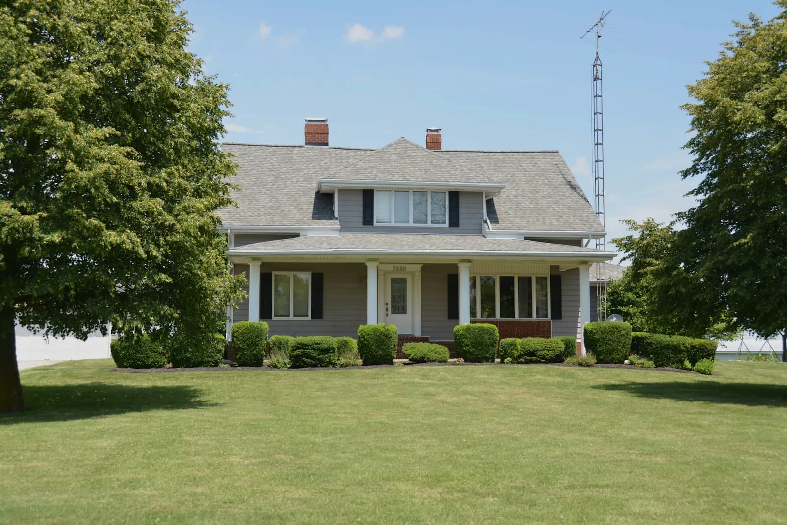 Two-story single-family home with a covered front porch and a mown front lawn